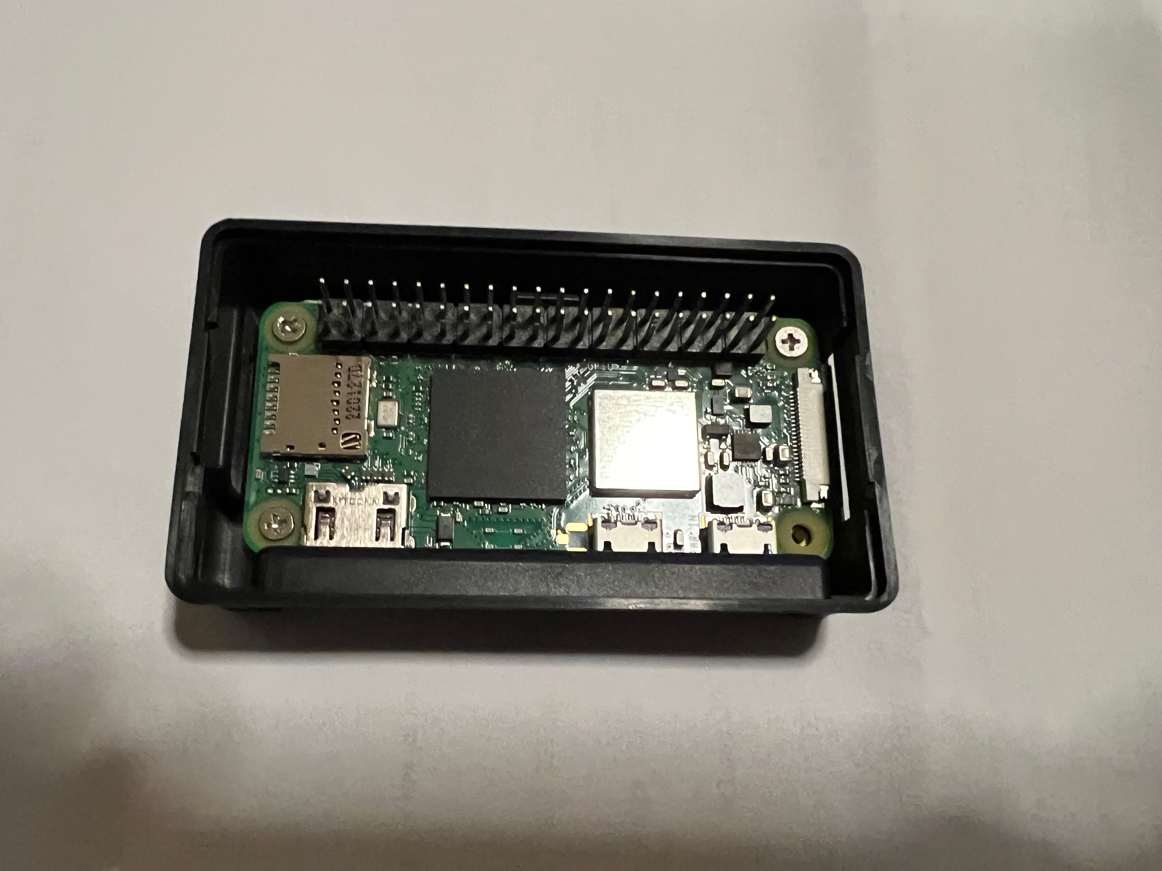 Raspberry Pi inserted into the bottom of the case, held in place by up to 4 screws (3 shown in the image)